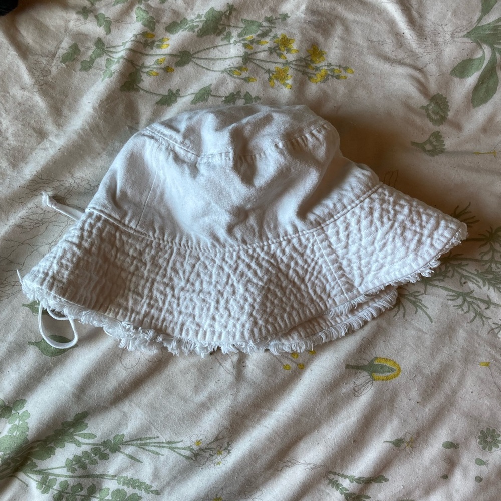 White summery bucket hat with fringe, size is adjustable